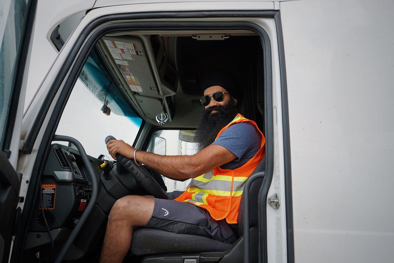 A driver in the seat of a truck cab