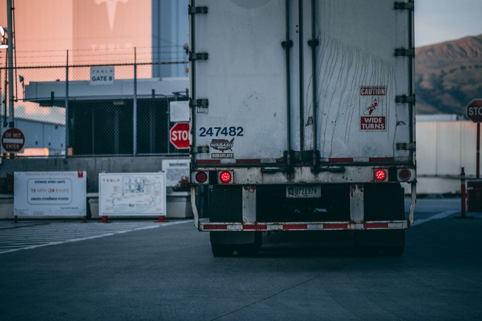 The rear of a trailer stopped at a fenced gate