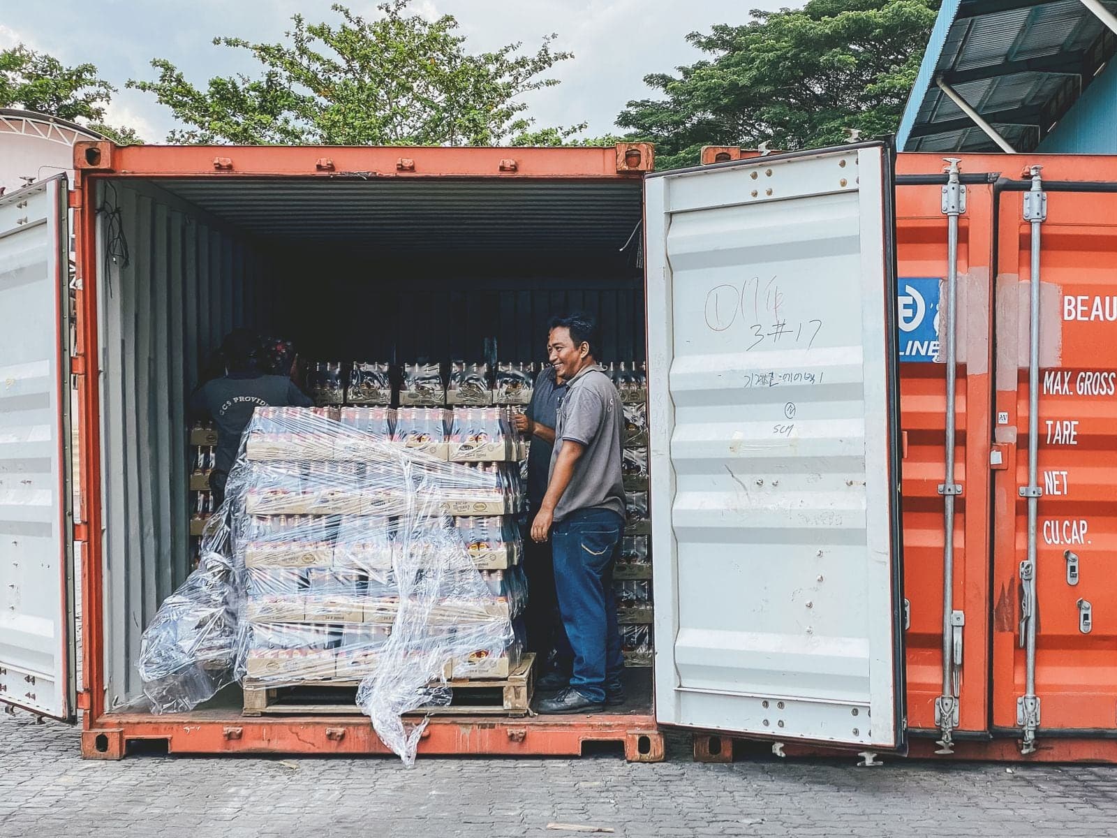 Two men at the open doors of a loaded container