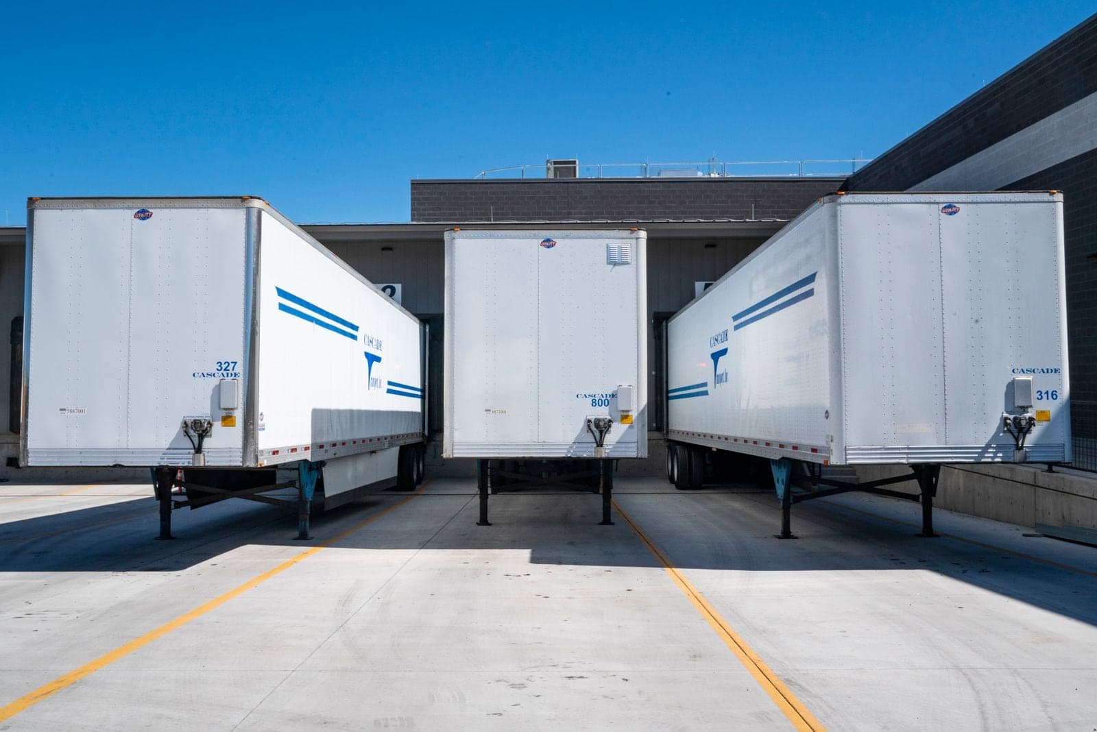 Three trailers parked at a warehouse dock