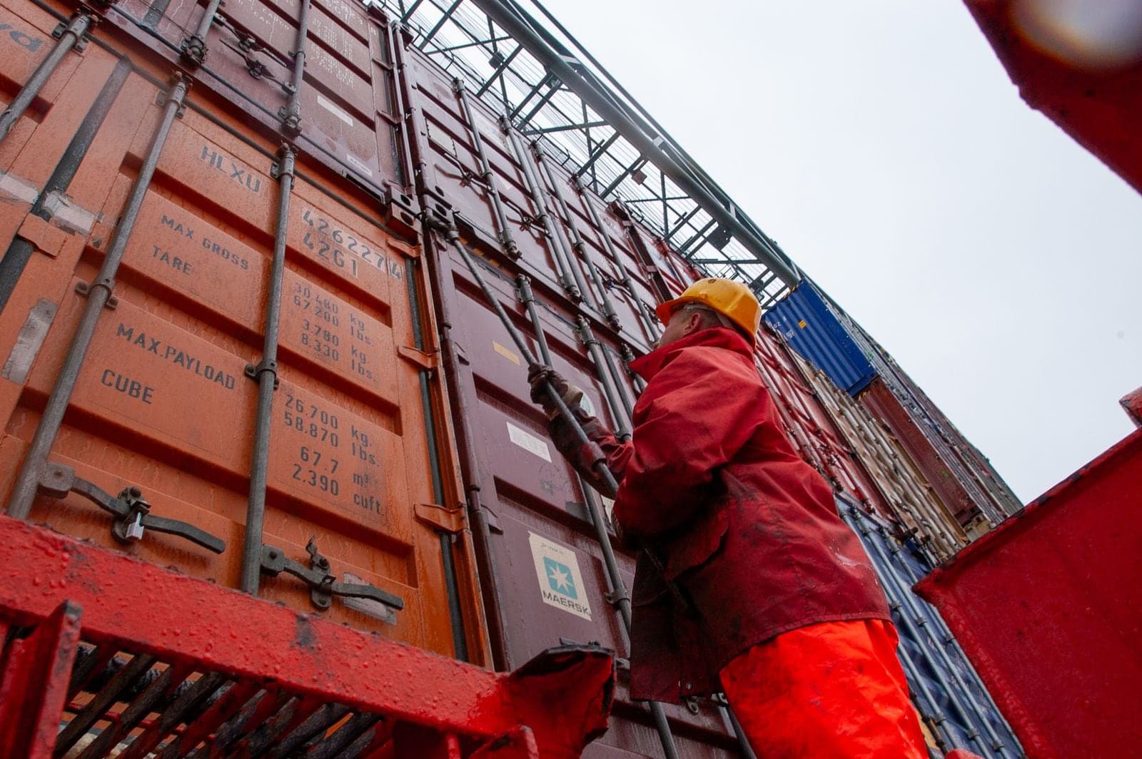 A worker on the locking bars of a shipping container