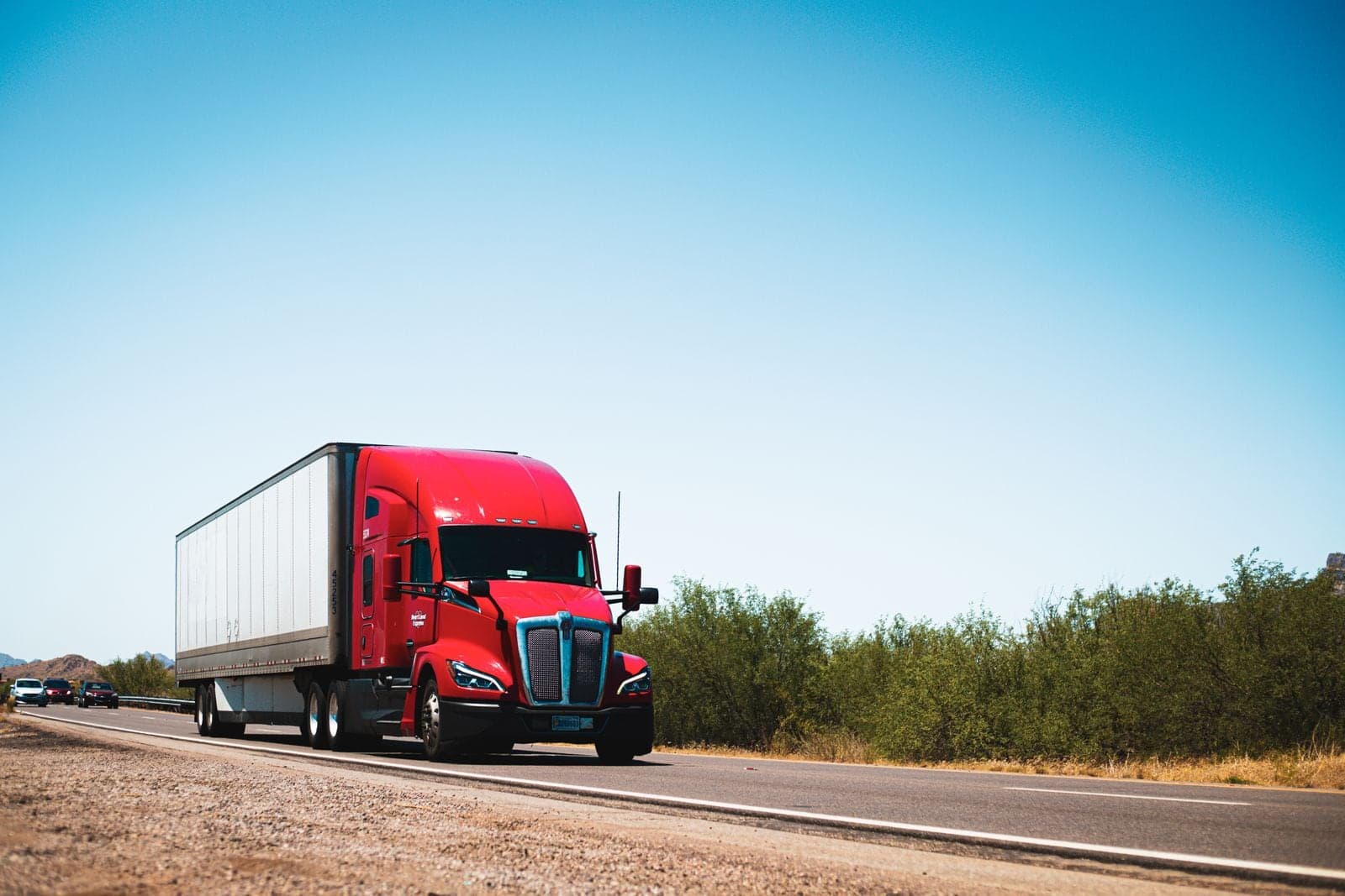 A red semi-truck on a highway